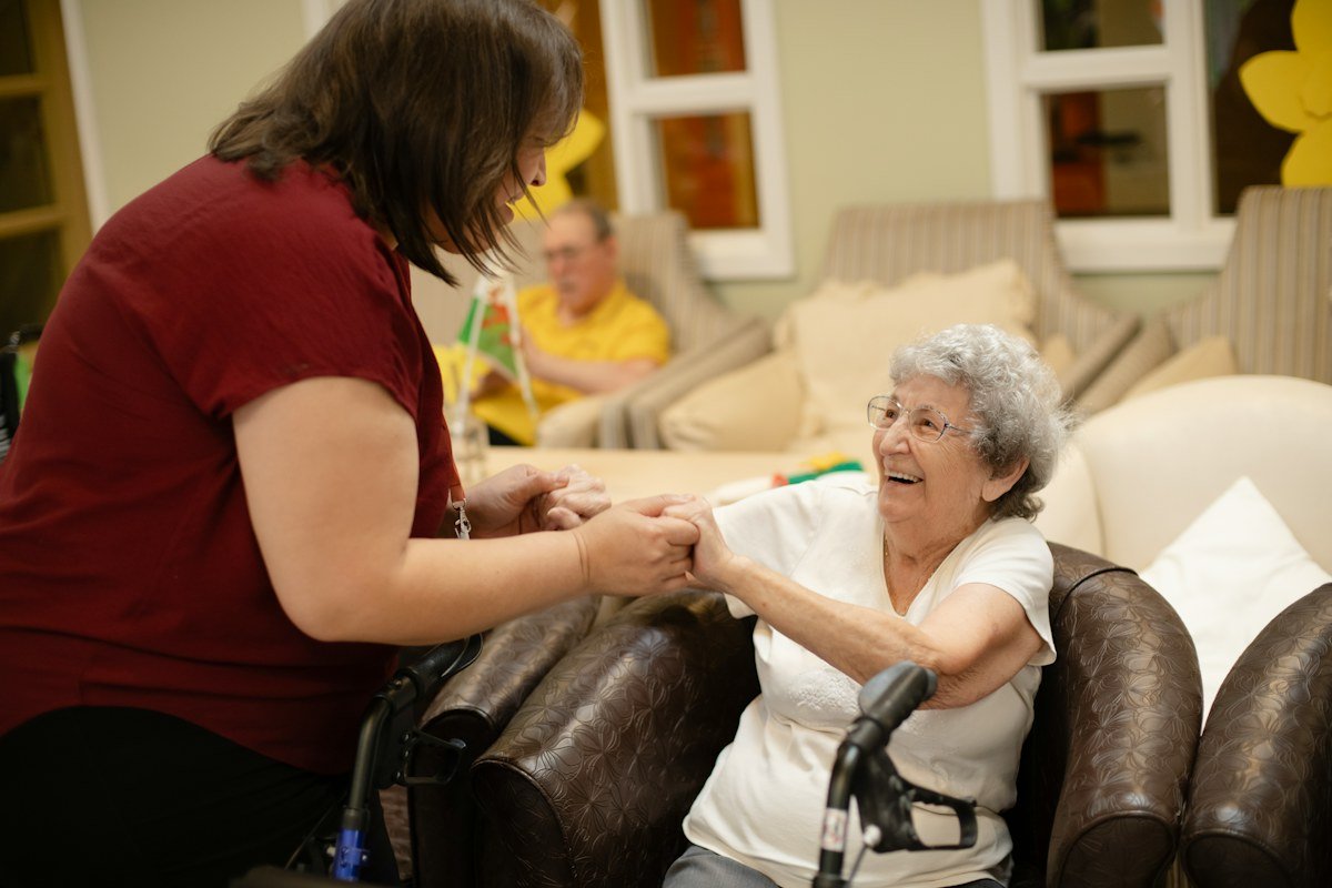 Older woman walking with supportive caregiver assistance