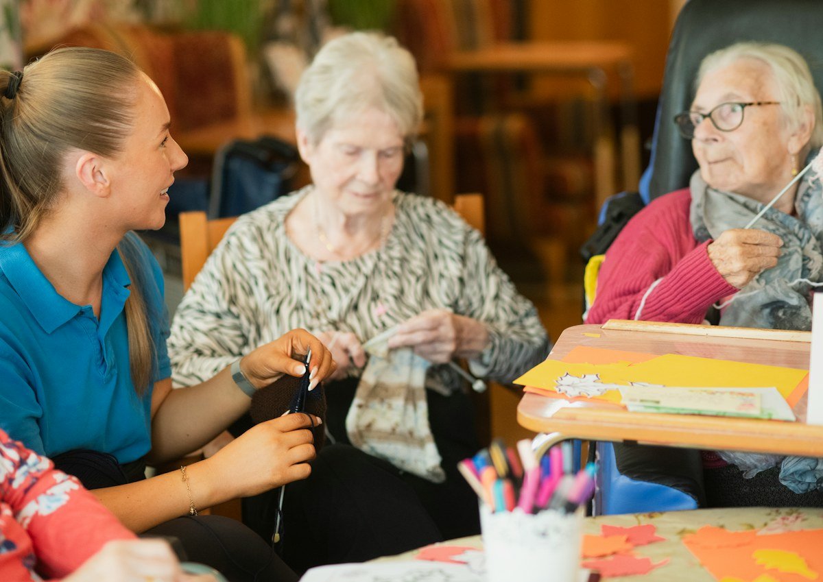 Older women enjoying an activity with a supportive caregiver