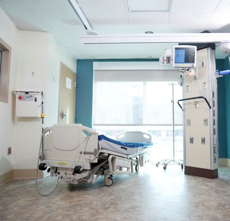 Empty hospital recovery room with an adjustable bed and medical equipment