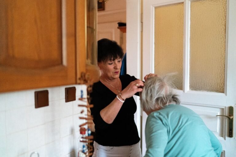 Caregiver assisting an older adult with grooming and dressing.
