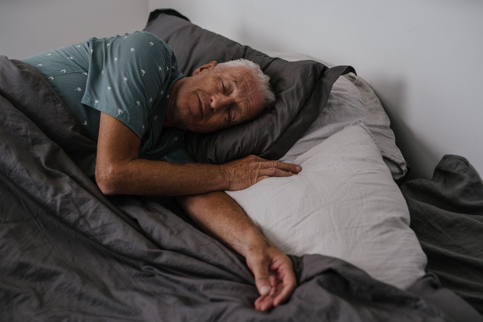 Older adult resting in bed in the morning.