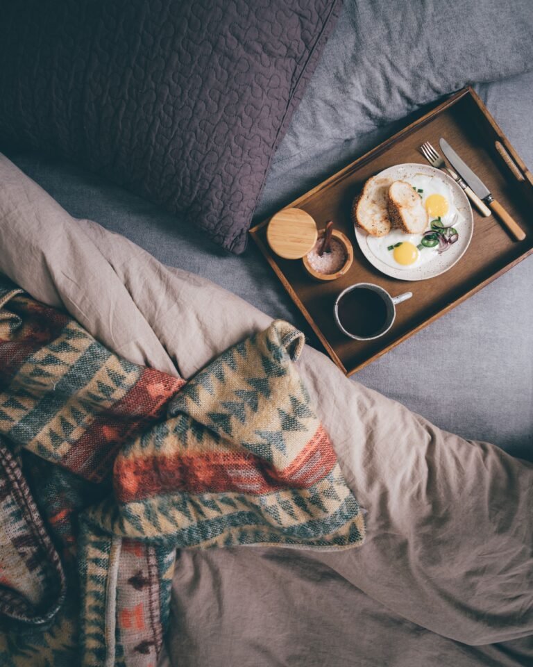 Breakfast tray arranged beside a bed.