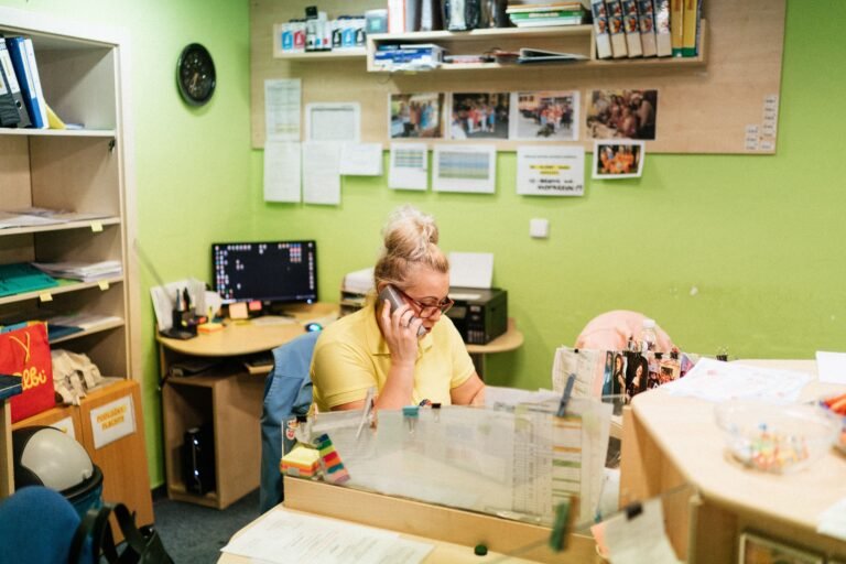 Caregiver speaking by telephone at a nursing home reception desk