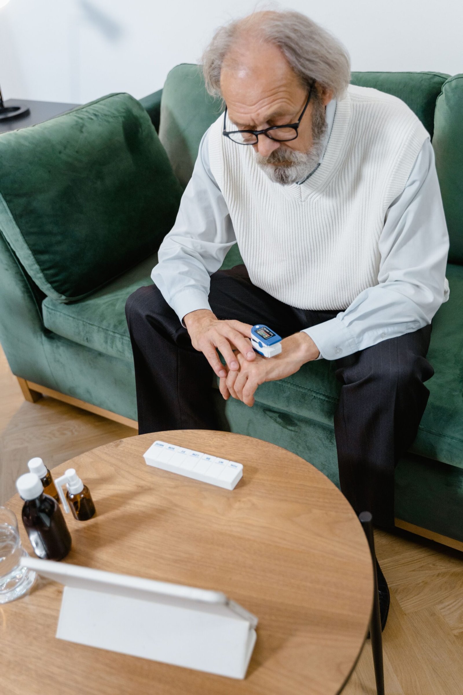 Older man checking his oxygen saturation with a pulse oximeter at home