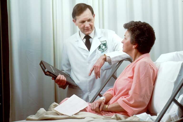 Hospital patient speaking with a doctor beside a medical bed