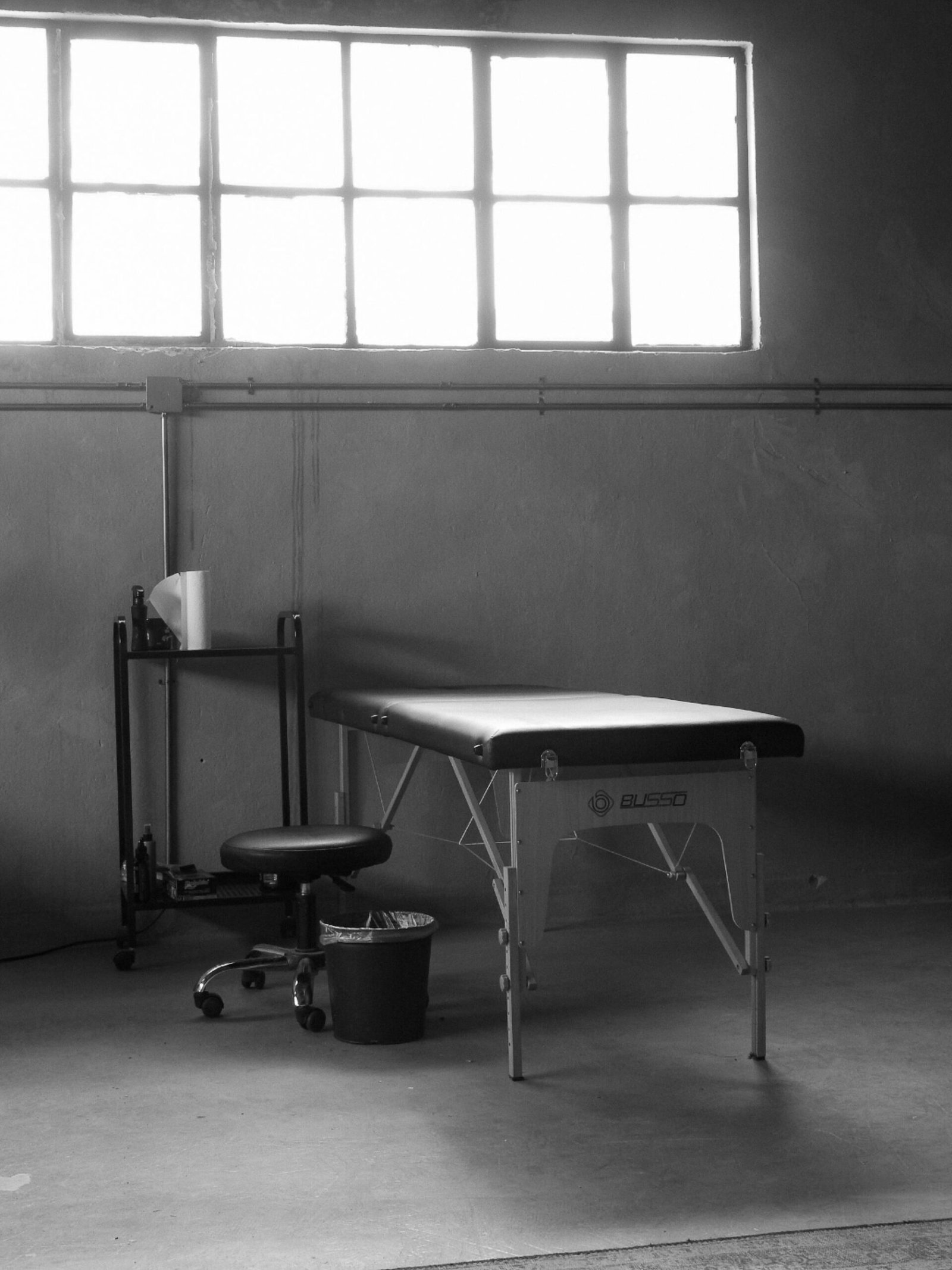 Empty therapy room with a treatment table near a window