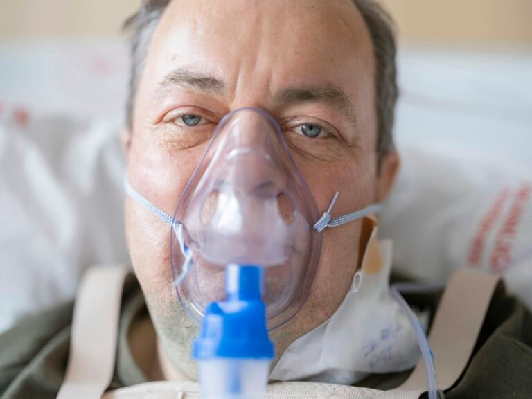 Older patient receiving respiratory support in a medical setting