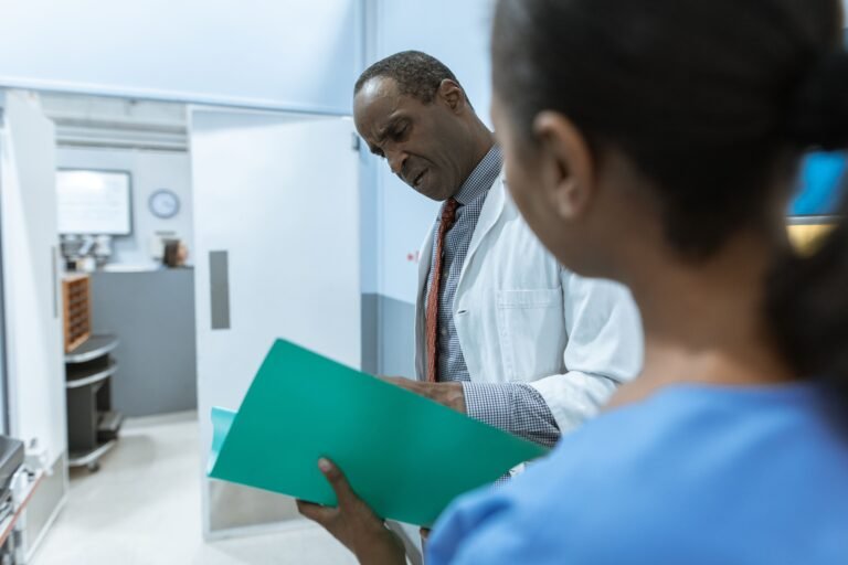 Doctor and nurse reviewing a medical folder together in a hospital.