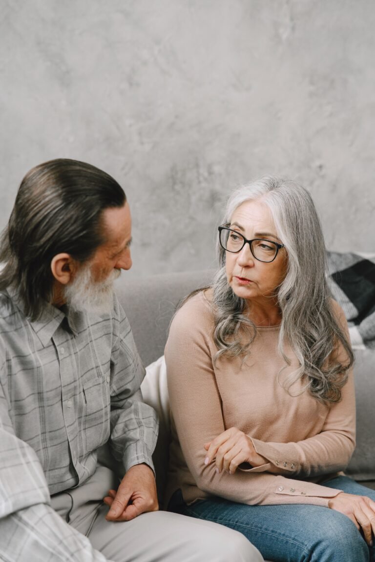 Older couple sharing a calm conversation indoors.