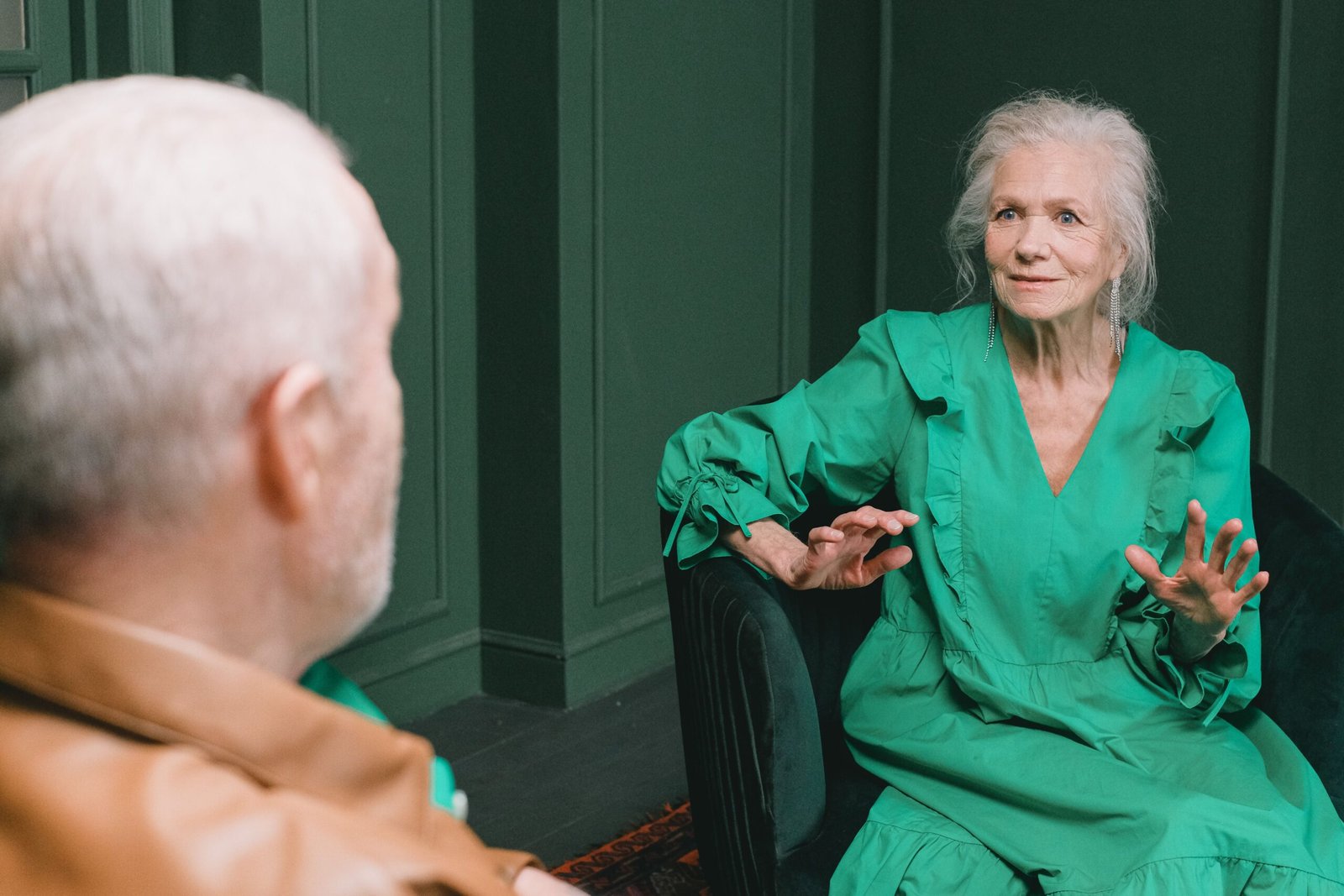 Older couple seated indoors during a conversation.