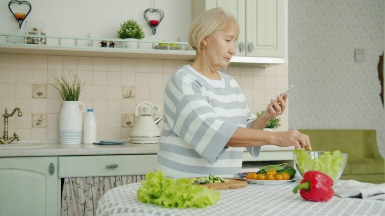 Older woman preparing a vegetable salad in her home kitchen