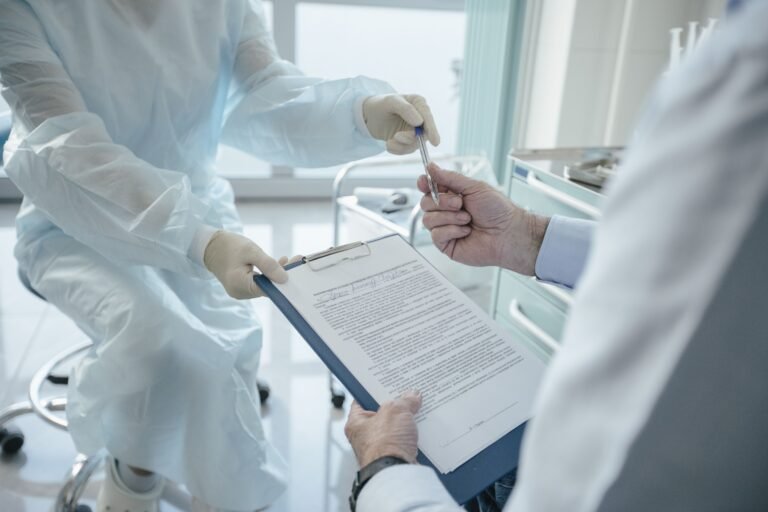 Healthcare professional handing a clipboard document to another person.