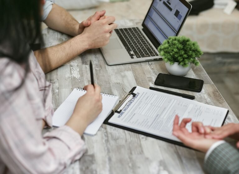 People reviewing insurance documents together at a desk.