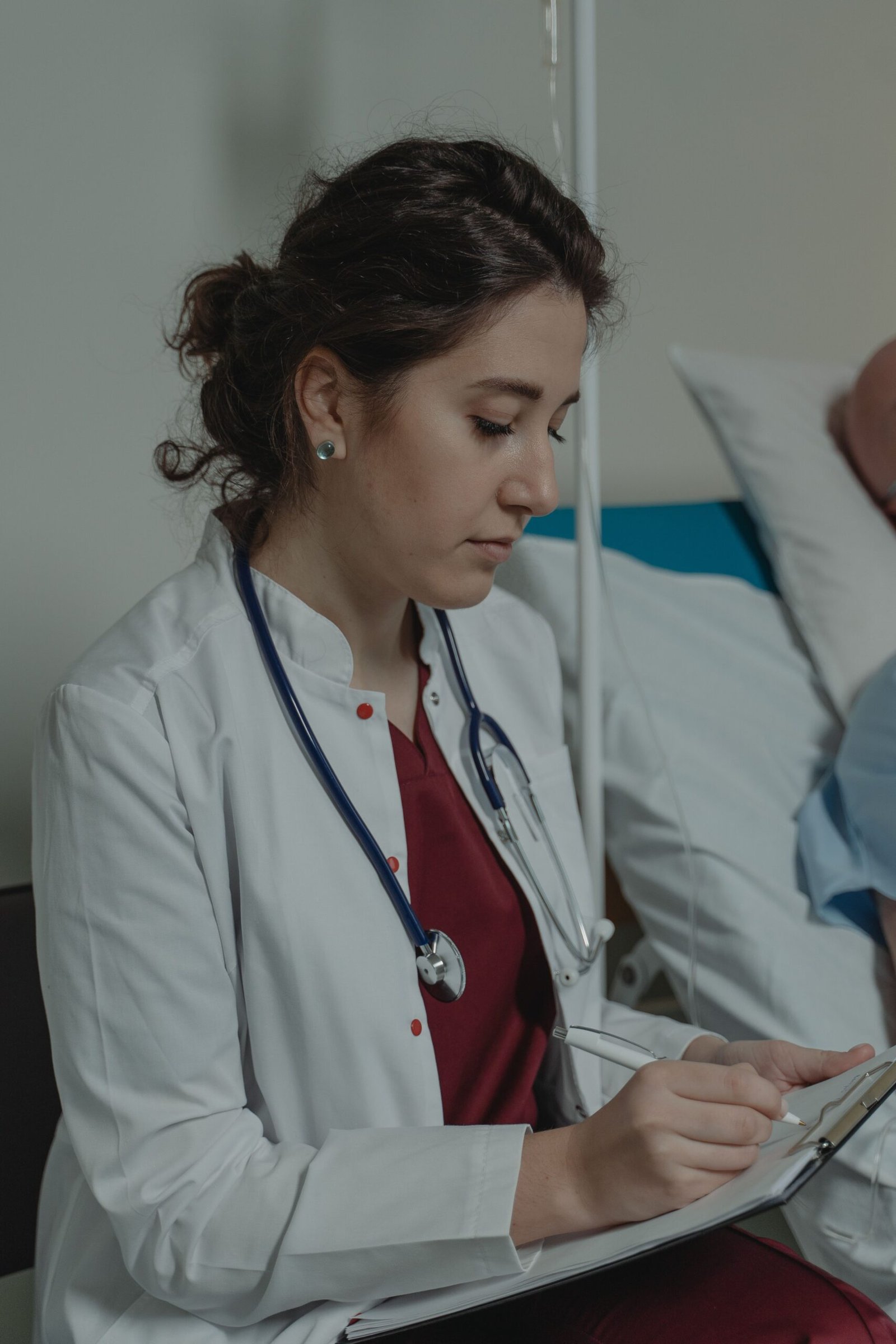 Healthcare professional writing notes on a clipboard.