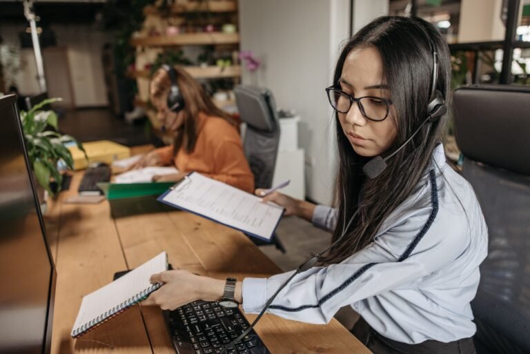 Customer-service worker wearing a headset while holding paperwork.