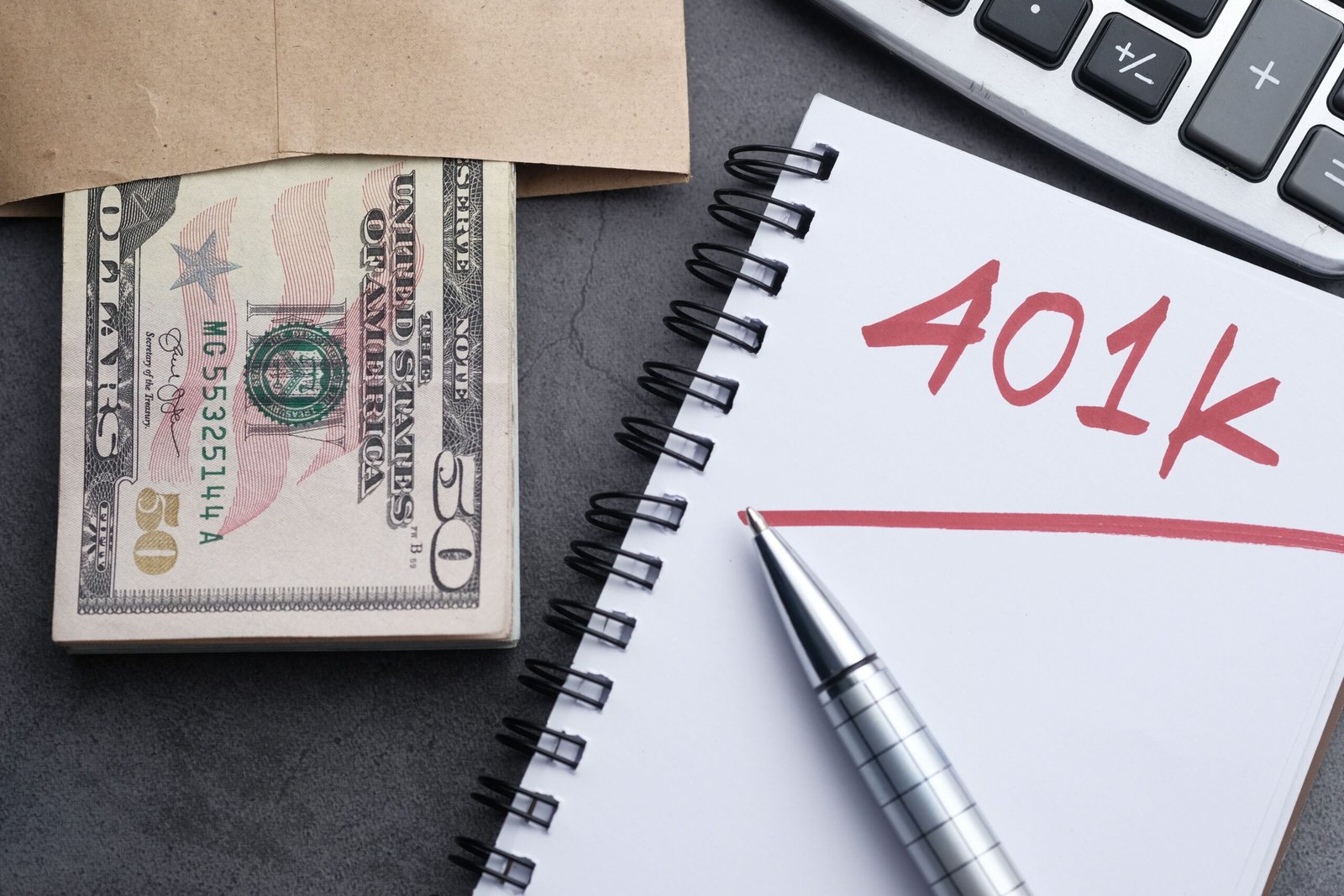Notebook, calculator, and cash arranged for financial planning.