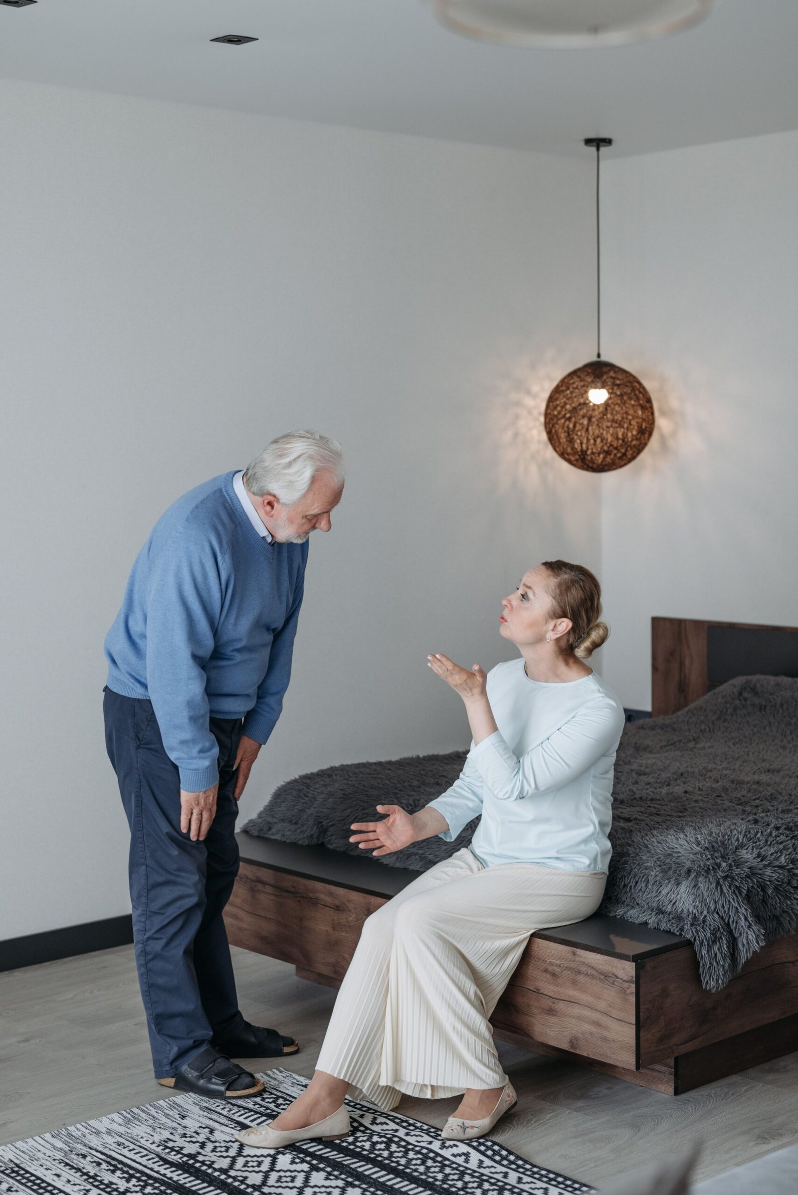 Older couple in a serious but supportive conversation indoors.