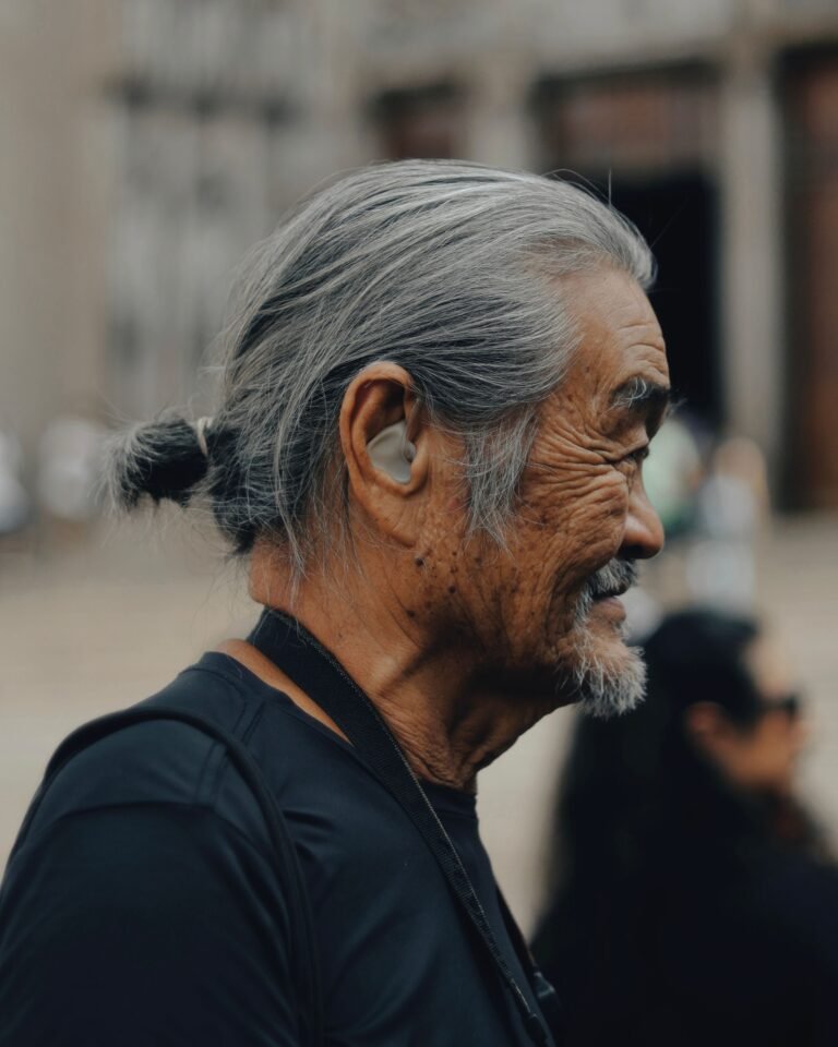 Close profile view of a hearing aid worn behind the ear