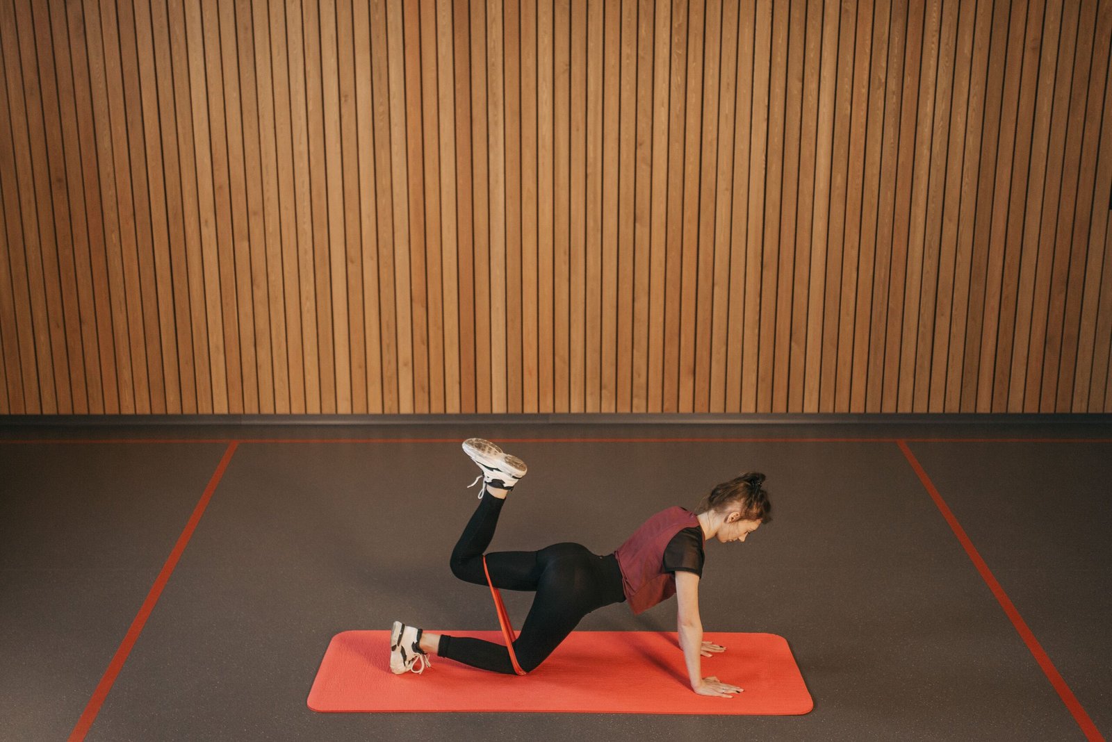 Person using a resistance band on an exercise mat during a general fitness session.