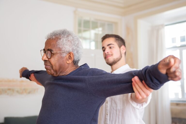 Older man doing a guided rehabilitation exercise with a caregiver