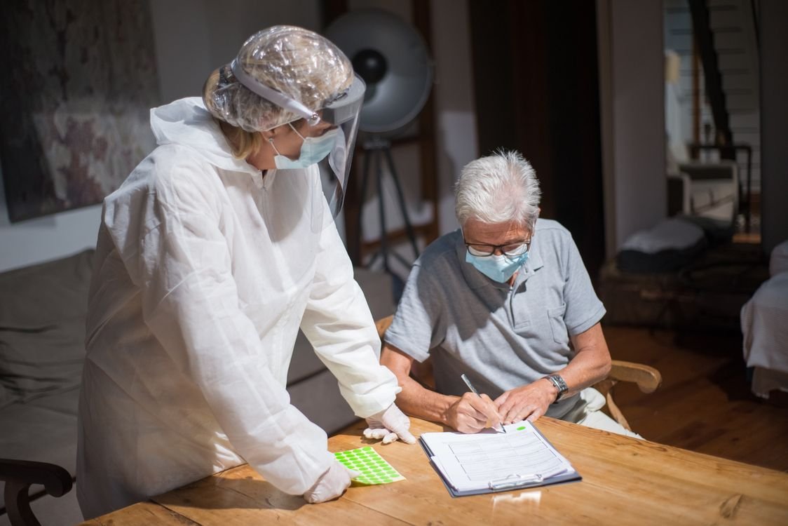 Healthcare worker reviewing paperwork with an older man