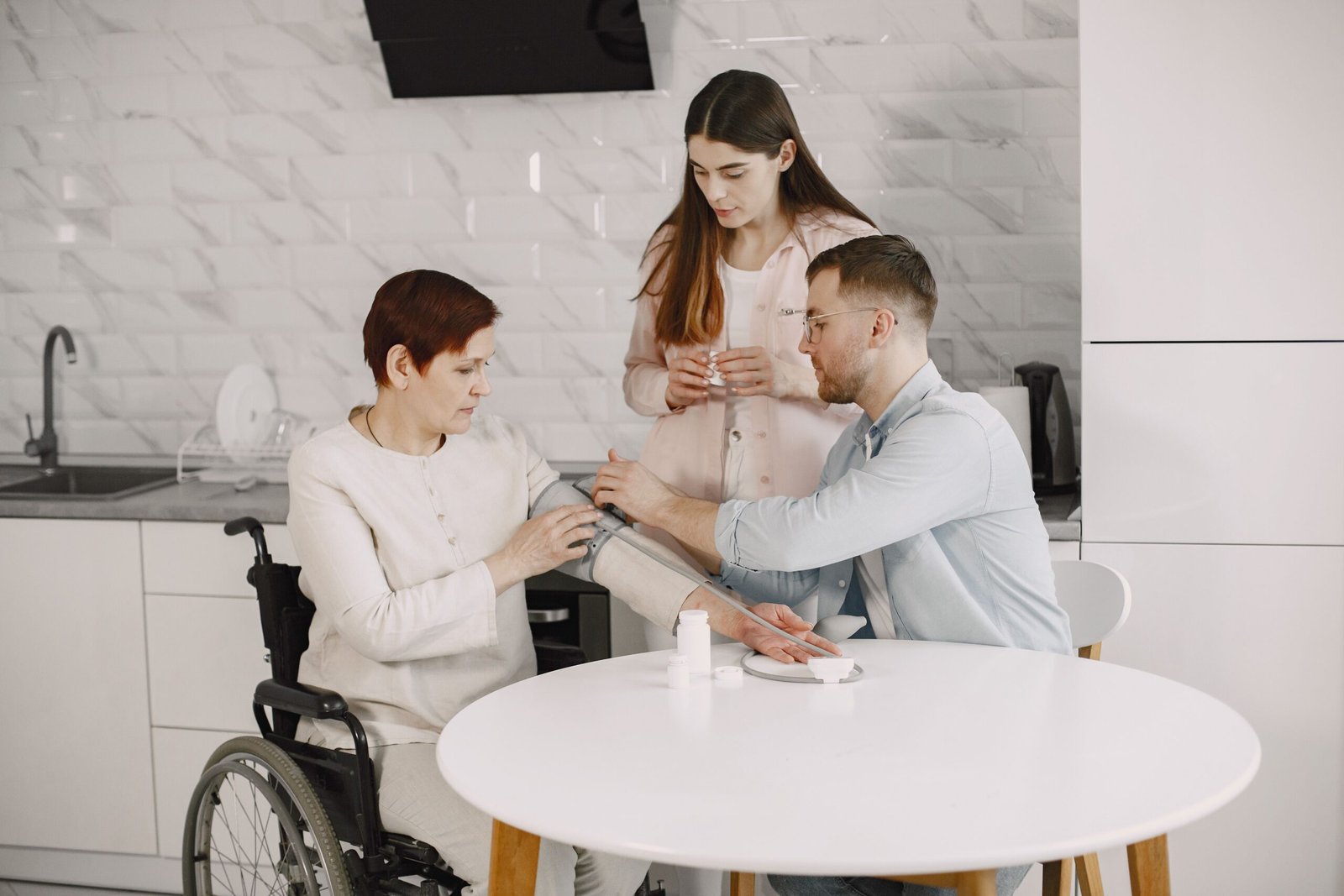 Family member checking an older woman's blood pressure at home