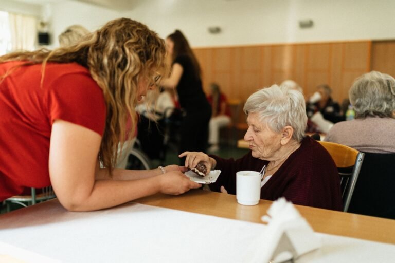 Caregiver helping an older woman with daily activities in a care facility
