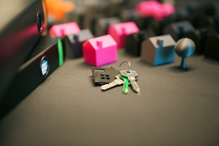 House keys and small model houses arranged on a desk.