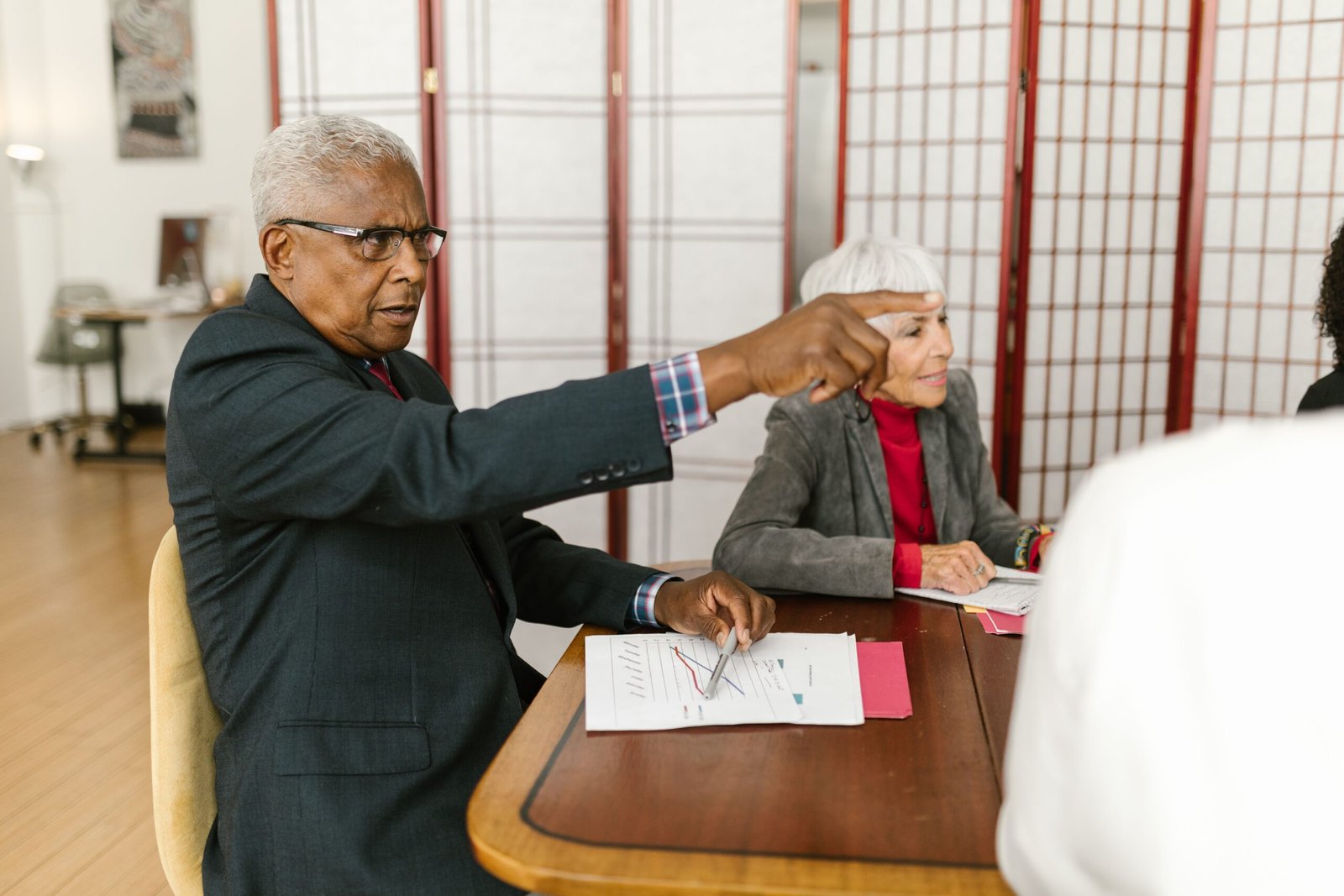 Older adults reviewing printed documents during a meeting