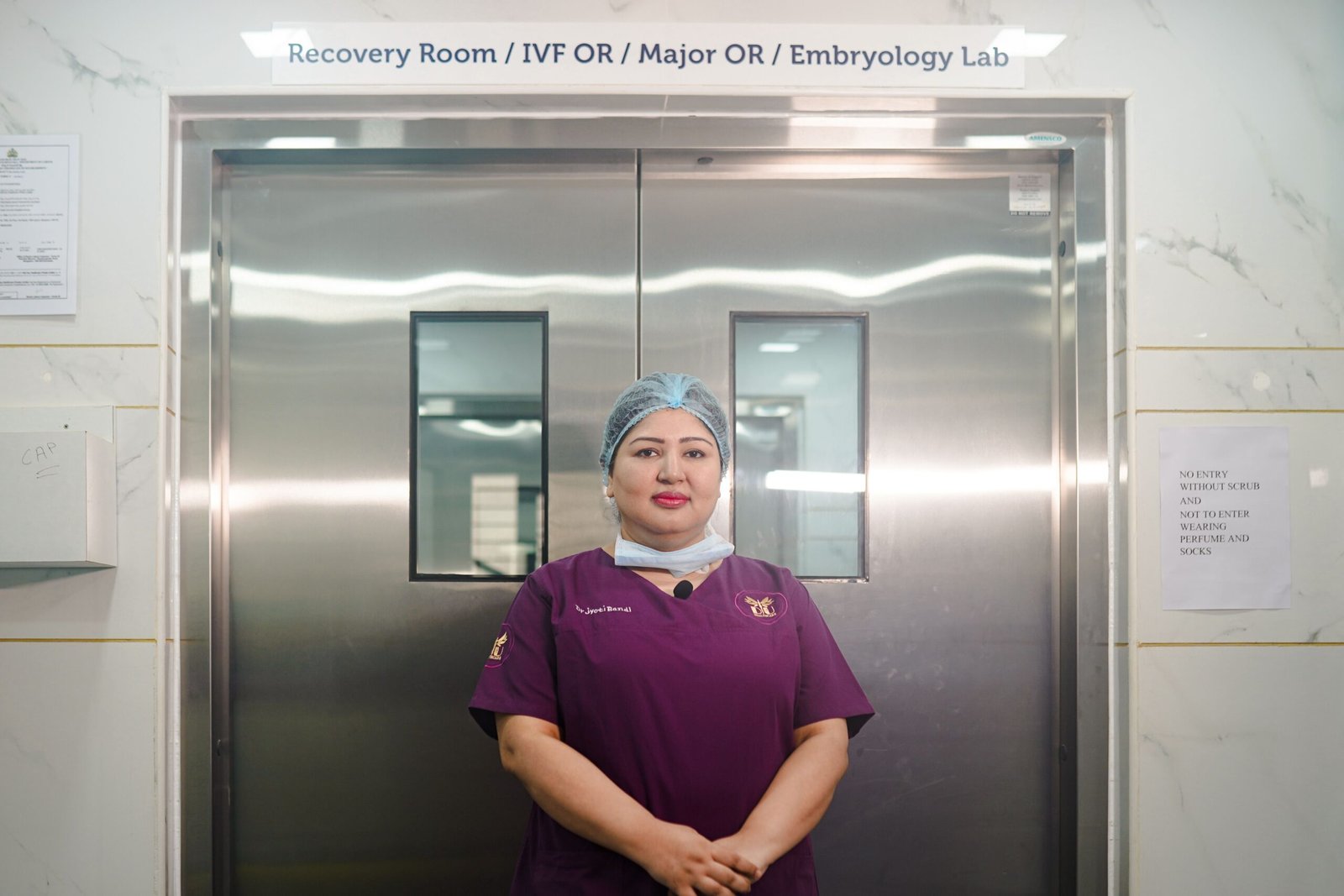 Healthcare professional standing in a bright hospital corridor.