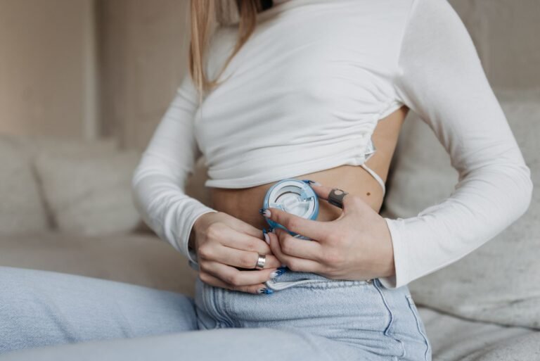 Close-up of hands placing a wearable insulin pump device
