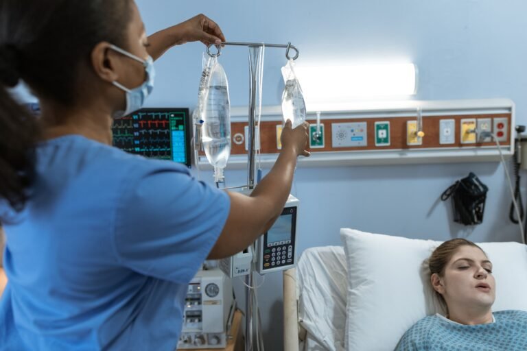 Nurse adjusting an intravenous medication bag for a patient in a hospital room