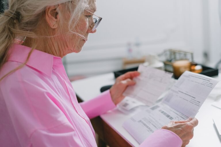 Older woman reading financial and care-related paperwork