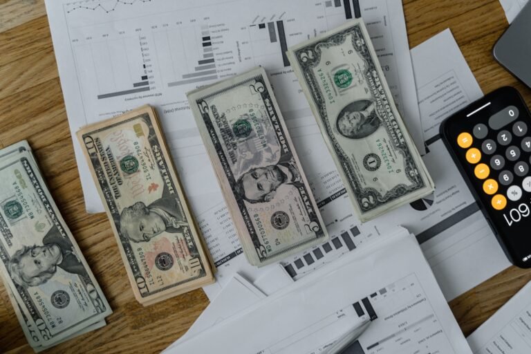 Financial planning documents, calculator, and cash on a desk.