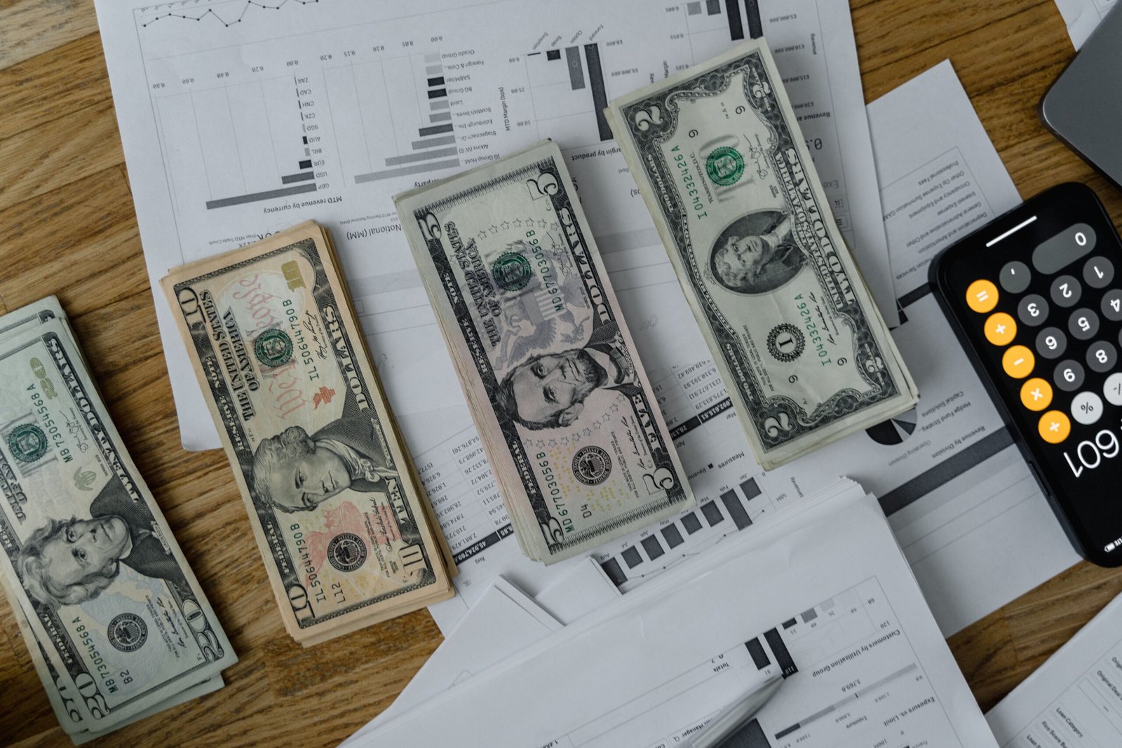 Financial planning documents, calculator, and cash on a desk.