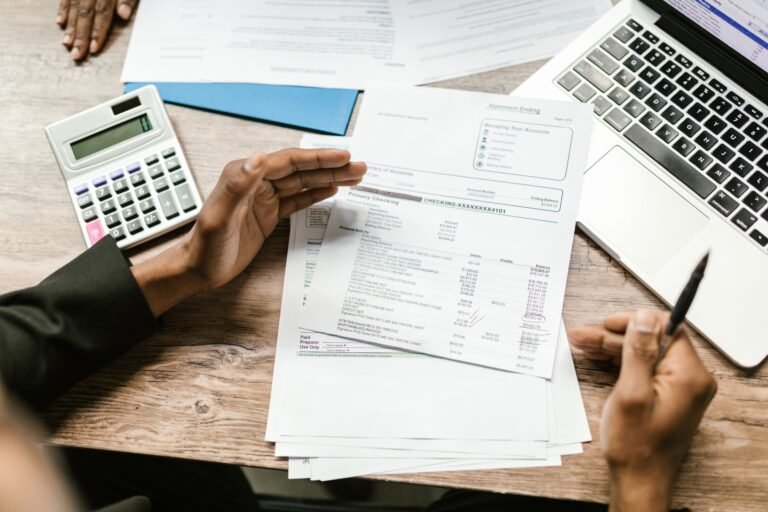 Financial documents and laptop arranged for benefits paperwork.