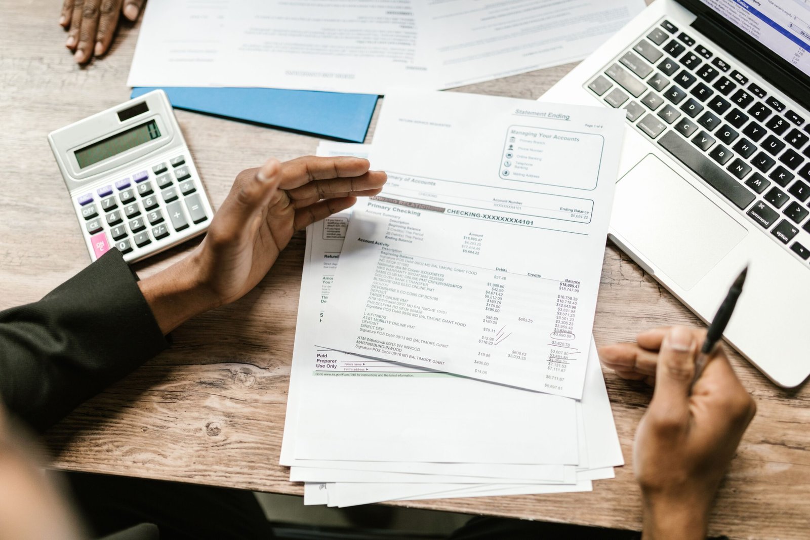 Financial documents and laptop arranged for benefits paperwork.