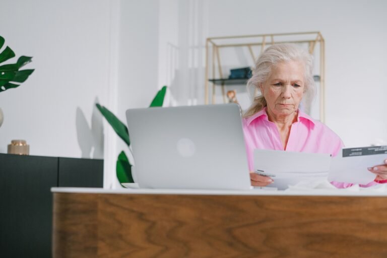 Older woman reviewing important documents and paperwork at home