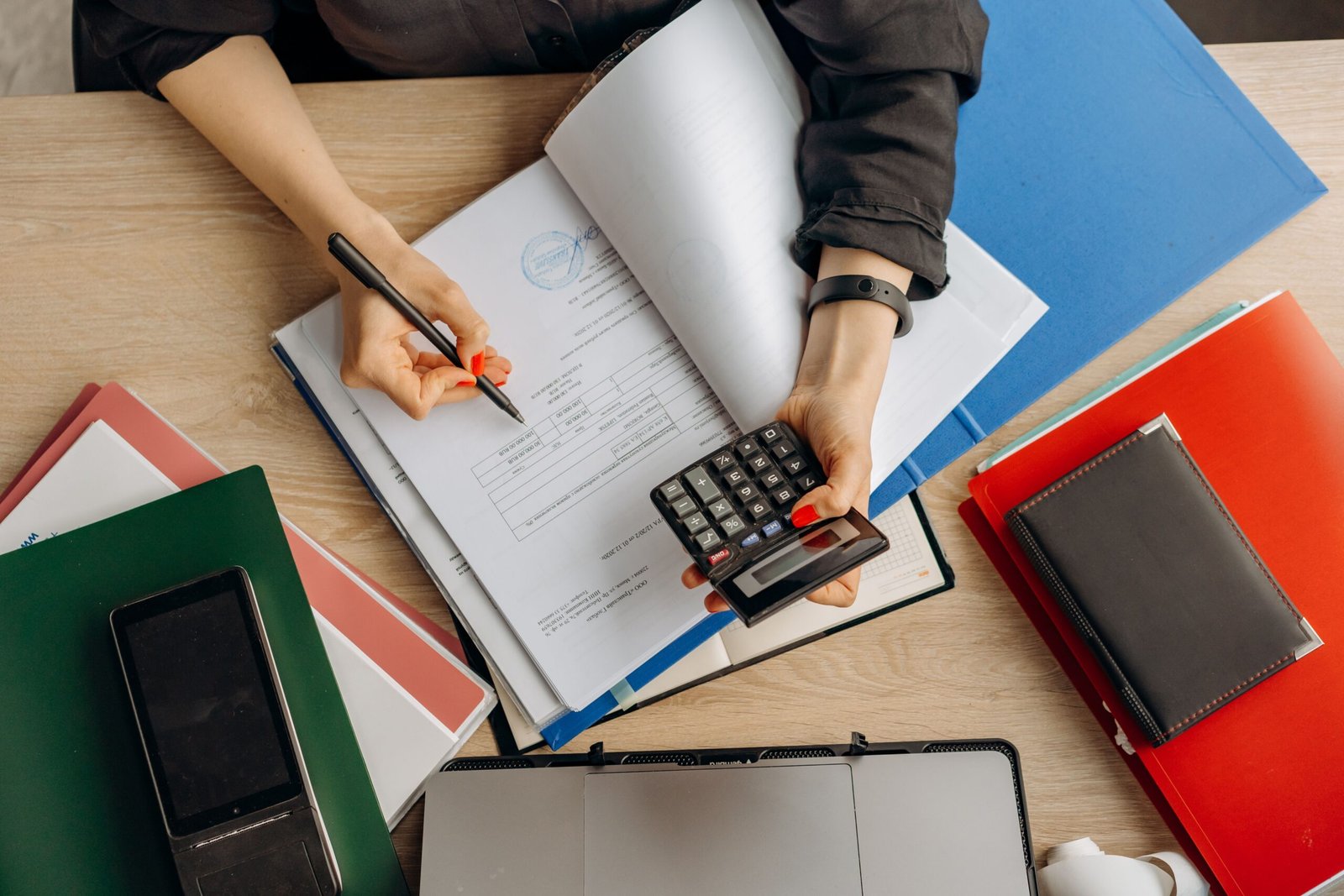 Person reviewing financial documents with a calculator.