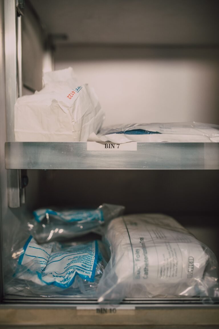 Medical supplies organized in labeled storage bins on shelves.