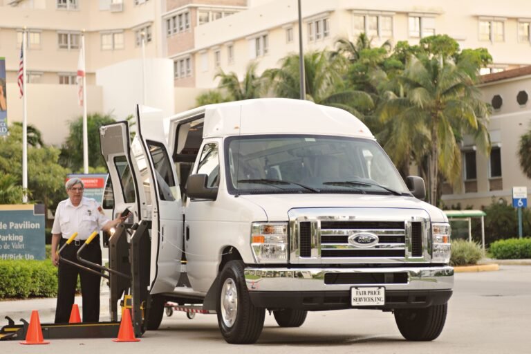 Accessible transportation van with wheelchair ramp and driver outdoors.