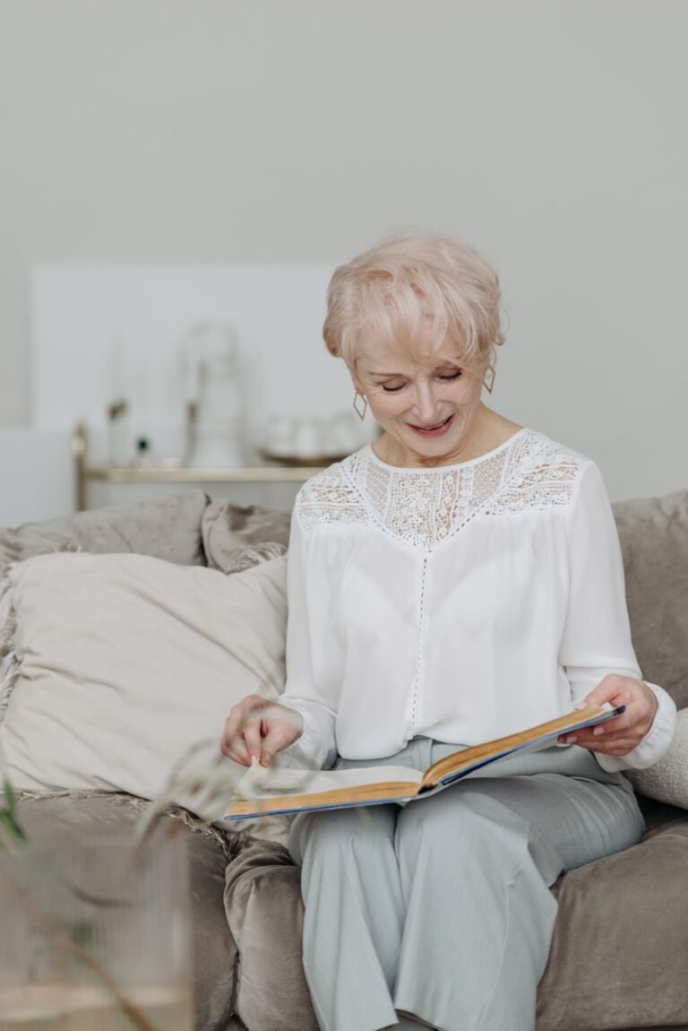 Older woman reading a book at home.