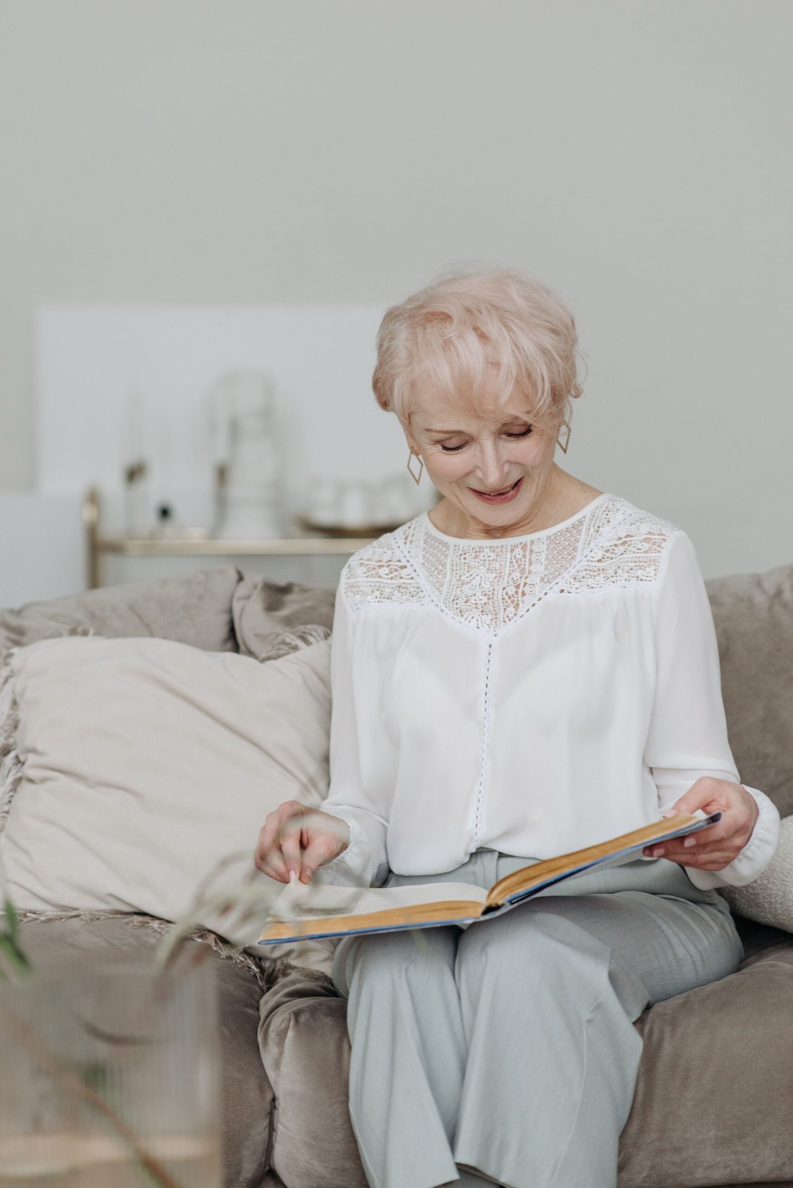 Older woman reading a book at home.