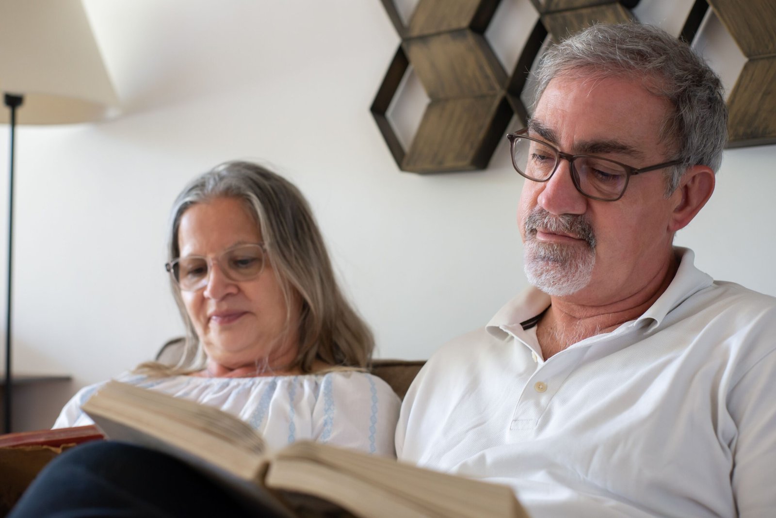 Older couple reading together at home.