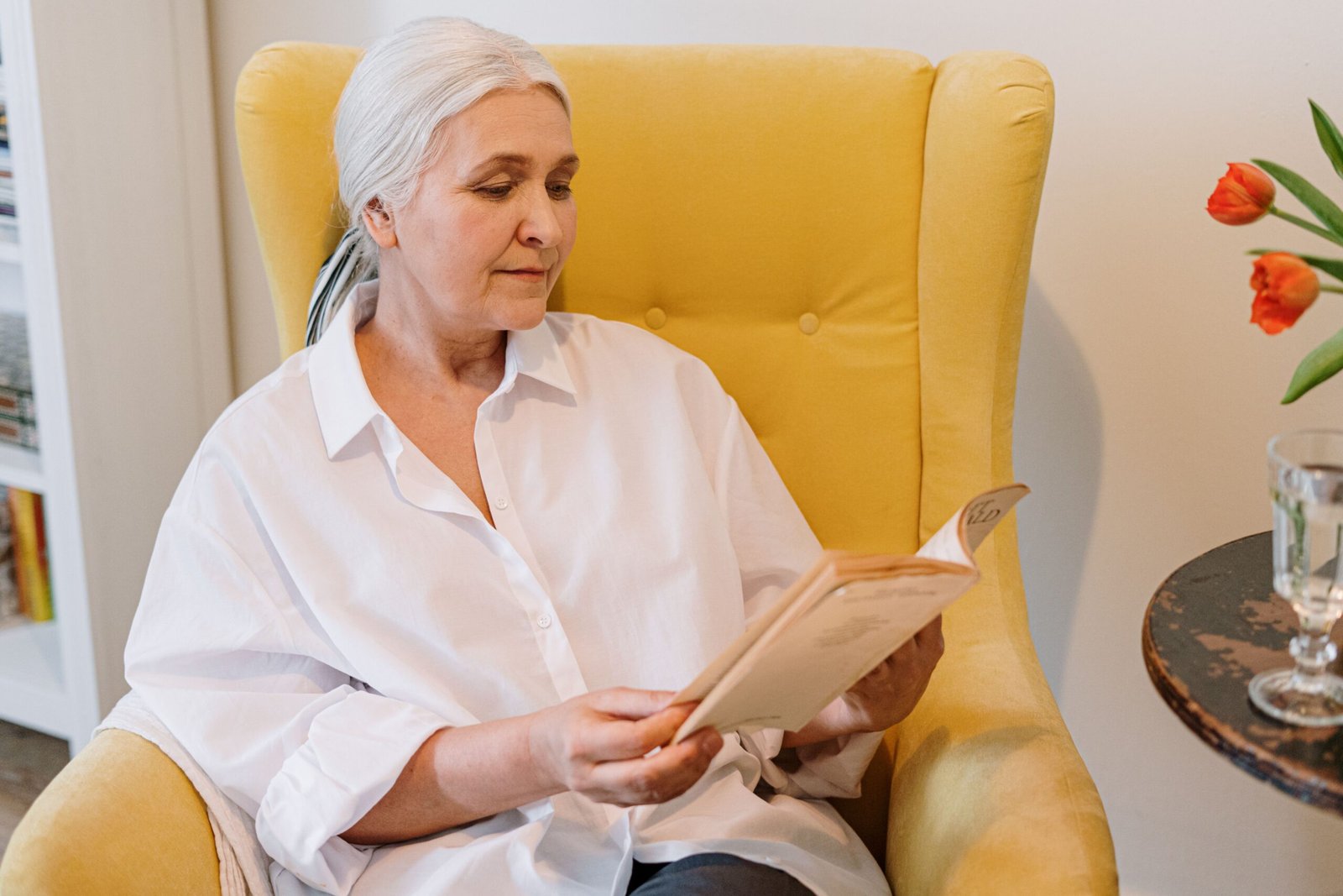 Older woman reading quietly in a comfortable chair.