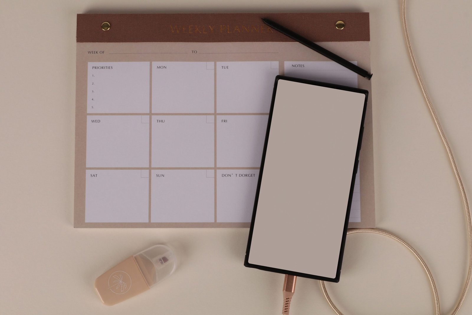Weekly planner and smartphone arranged on a desk for scheduling and follow-up.