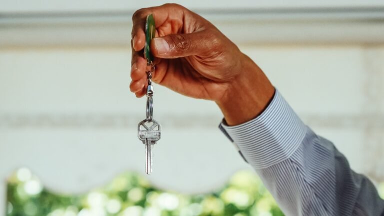 A hand holding a small set of house keys.