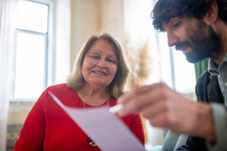 Older woman and a man reviewing paperwork together during a seated conversation