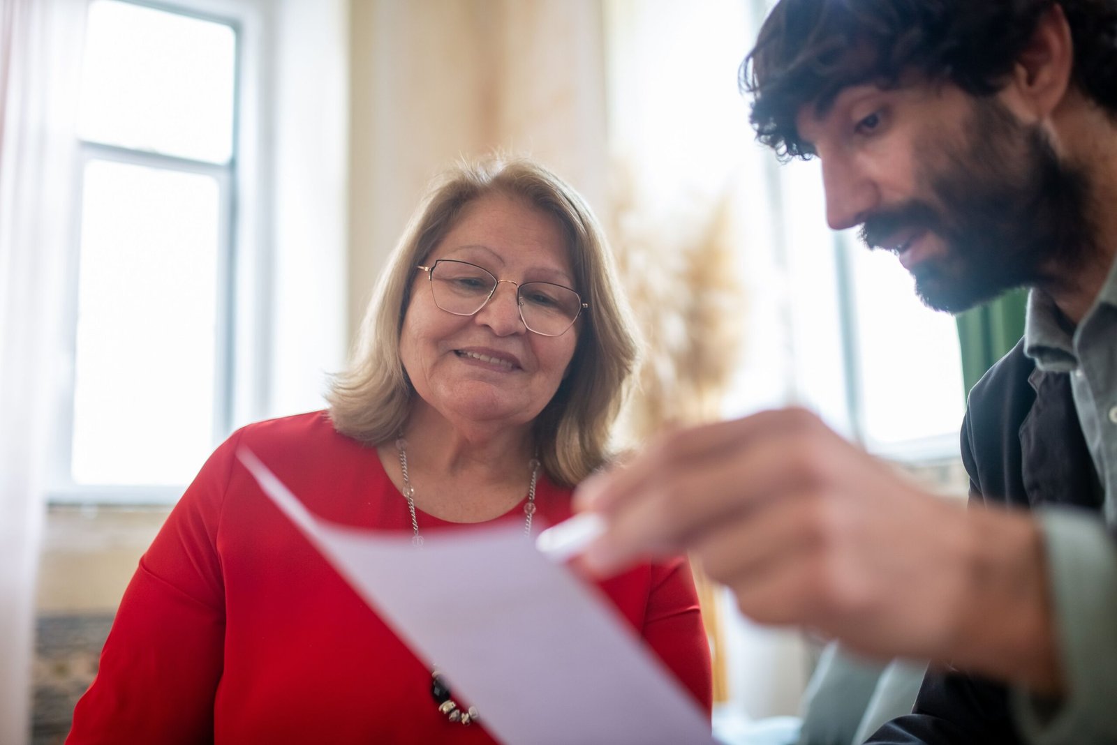 Older woman and a man reviewing paperwork together during a seated conversation