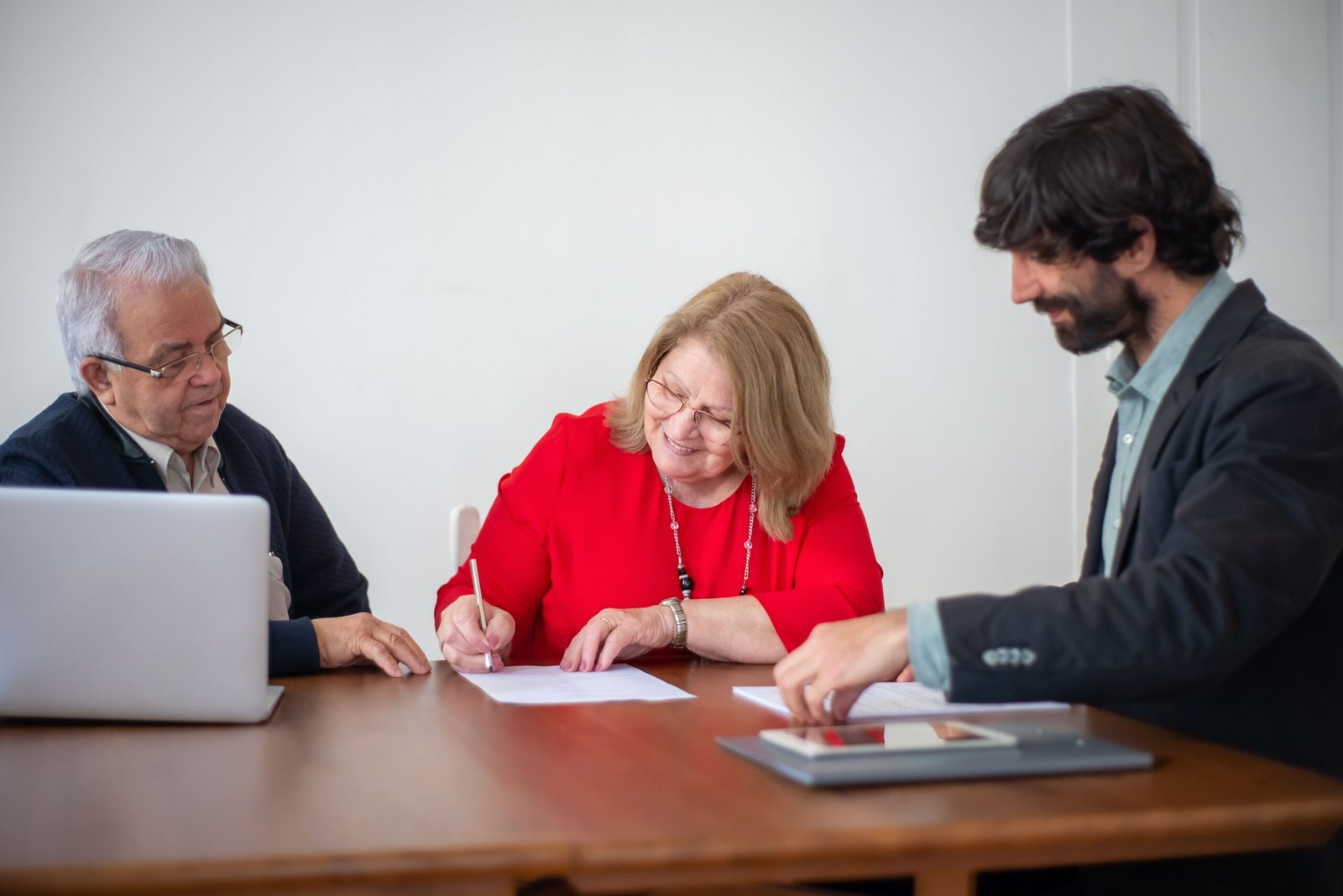 Older adults reviewing and signing documents during a meeting